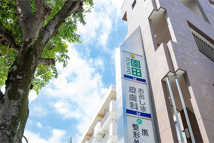 7.茶色いビルの当院看板が見えてきます。